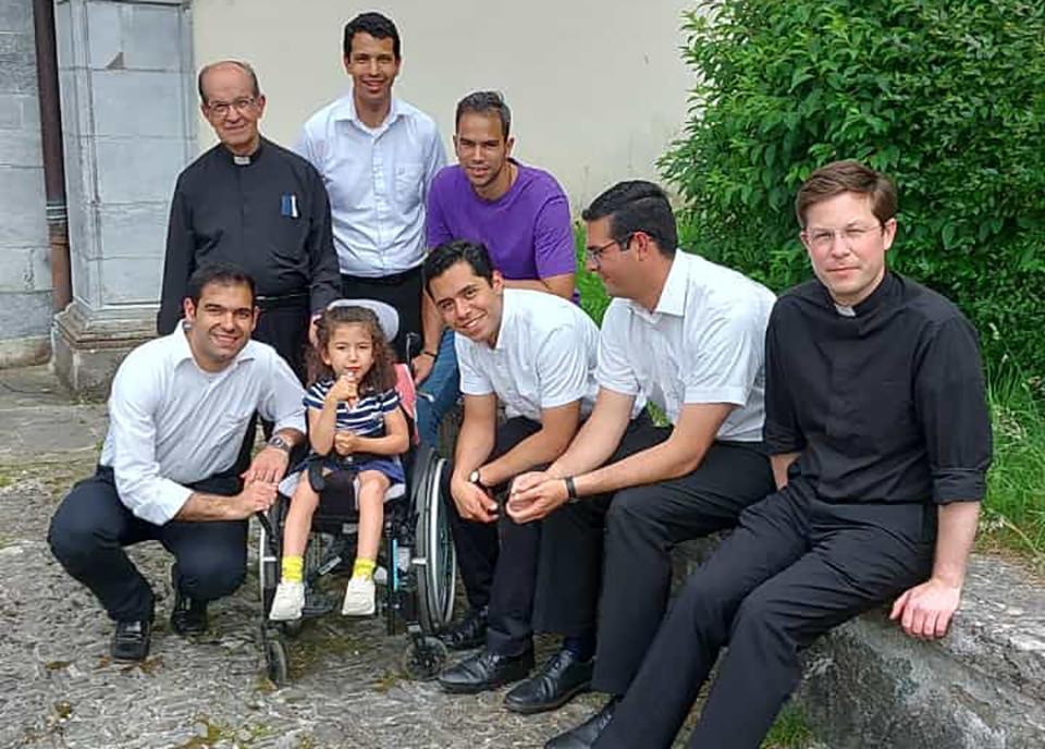 Los legionarios de Cristo presentes en Lourdes con una niña enferma en silla de ruedas.