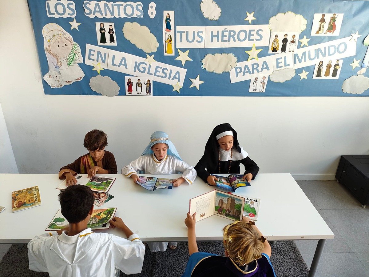 Alumnos de primaria de Highlands School Barcelona, en el rincón de la lectura leyendo libros con vidas de santos en la celebración de Holywins