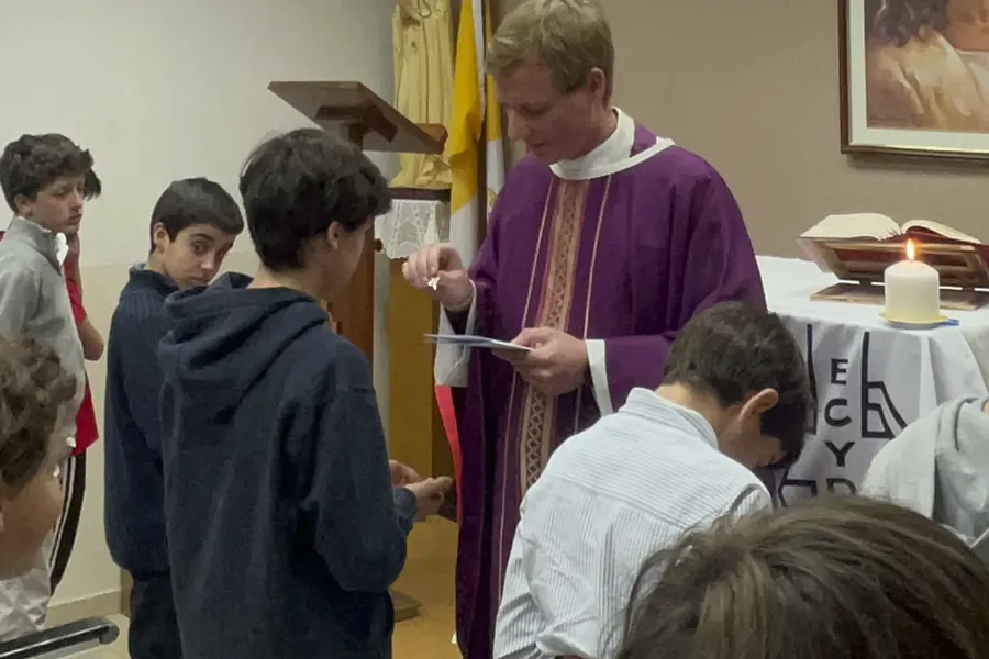 El P. Marcin entrega la cruz del ECYD a uno de los chicos que hizo la Alianza con Jesús