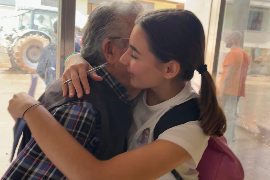 Marina Hurtado da un abrazo a un mayor al que va a entregar una de las cartas