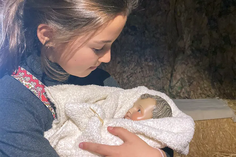 Una alumna de Everest School Monteclaro con el Niño Jesús en la gruta de Belén